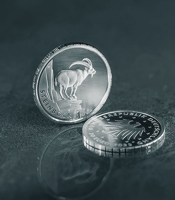 Zwei Silbermünzen, eine mit einem Steinbock-Motiv, die andere mit dem Adler der Bundesrepublik Deutschland.