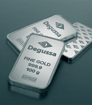 Mehrere Degussa-Goldbarren mit 999,9 Feingold-Prägung auf dunkler Fläche.